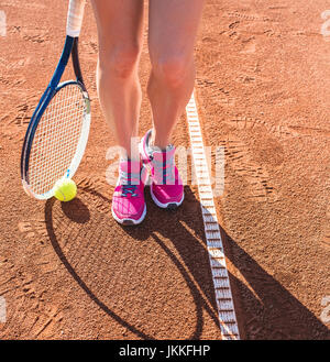 Weibliche Beine mit Tennisschläger Stockfoto