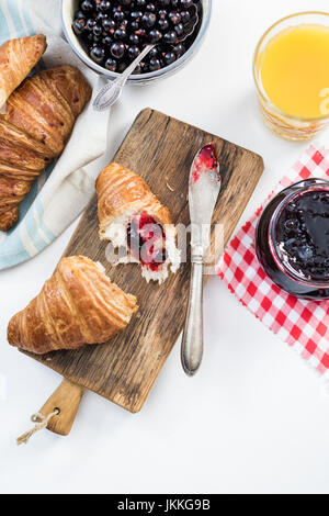 Frische Croissant mit Blaubeeren Marmelade auf Holzbrett serviert Stockfoto