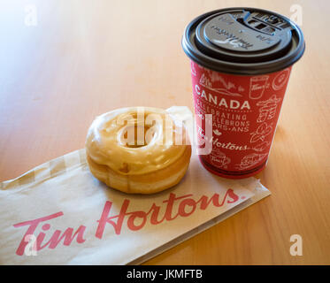 Ein Tim Hortons Ahorn Dip Krapfen und Kaffee. Stockfoto