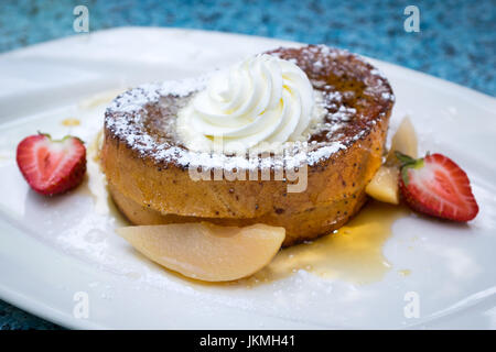 Wunderschön plattiert Zimt French Toast (eggy Brot) mit Sahne, Ahornsirup, Vanille pochierte Birnen und Erdbeeren. Stockfoto