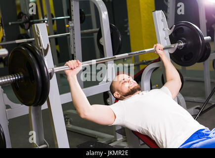 Starker Mann läuft Übung für die Brust in der Turnhalle. Sport, Bodybuilding, Training und Menschen-Konzept Stockfoto