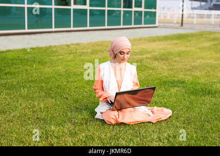 wunderschöne muslimische Frau im Park mit notebook Stockfoto