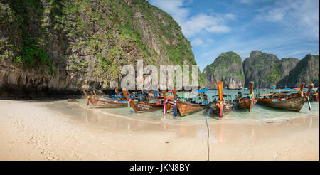 KRABI, THAILAND - 4. Dezember: Bunte Longtailboote am Strand auf einem Hintergrund des blauen Himmels und azurblauen Meer und Kalkstein Felsen, Phi Phi Isla Stockfoto