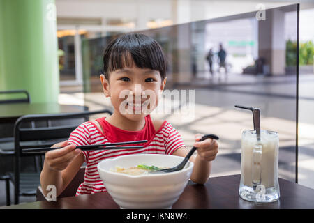 Asiatische chinesische Mädchen essen Nudelsuppe im Café im freien Stockfoto