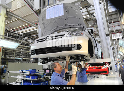 Sao Paulo, Brasilien. 4. Oktober 2011. Arbeiter Stand unter einem VW Gol am Fließband im Montagewerk für Volkswagen Anchieta in Sao Bernardo Compo in der Nähe von Sao Paulo, Brasilien, 4. Oktober 2011. Deutsche Autohersteller VW ist 3,4 Milliarden Euro in seine brasilianische Montagewerke bis 2016 zu investieren. Foto: Julian Stratenschulte | weltweite Nutzung/Dpa/Alamy Live-Nachrichten Stockfoto