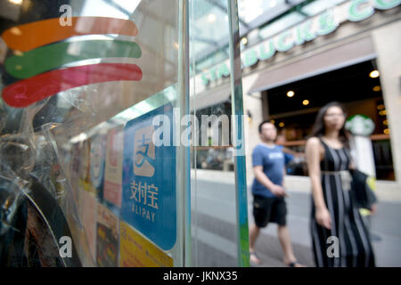 (170724)--KUALA LUMPUR, 24. Juli 2017 (Xinhua)--Fußgänger vorbeigehen eine Datenverwaltung mit dem Logo der Alipay auf die Glastür in Kuala Lumpur, Malaysia, 24. Juli 2017. Malaysias zweitgrößte Bank CIMB kam Hände mit finanziellen Ameise, einer Tochtergesellschaft der chinesische e-Commerce Riese Alibaba, am Montag, um lokale mobile-Payment-Anforderungen gerecht zu werden. (Xinhua/Chong Voon Chung) (Srb) Stockfoto