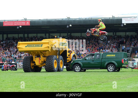 Royal Welsh Show - Montag, 24. Juli 2017 - das Känguru-Kind Motorrad Stuntman niedrig ist wie er versucht, einen grünen Pickup-Truck und einem großen gelben Muldenkipper vor den Zuschauern auf der Royal Welsh Show springen. Seine Quad-Bike trifft jenseits des gelben Kipper LKW wirft ihn zu Boden. Der Stuntman war von Krankenwagen Zustand unbekannt mitgenommen. Heute ist Tag der Eröffnung der größten viertägige Landwirtschaftsausstellung in Großbritannien. Foto-Steven Mai / Alamy Live News Stockfoto