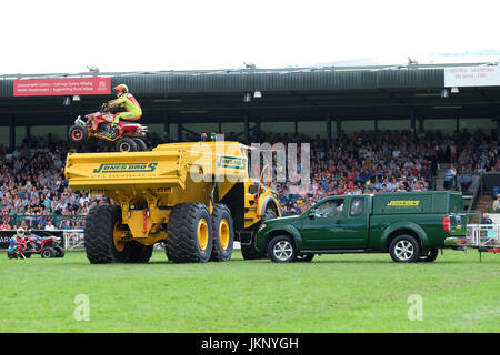 Royal Welsh Show - Montag, 24. Juli 2017 - das Känguru-Kind Motorrad Stuntman niedrig ist wie er versucht, einen grünen Pickup-Truck und einem großen gelben Muldenkipper vor den Zuschauern auf der Royal Welsh Show springen. Seine Quad-Bike trifft jenseits des gelben Kipper LKW wirft ihn zu Boden. Der Stuntman war von Krankenwagen Zustand unbekannt mitgenommen. Heute ist Tag der Eröffnung der größten viertägige Landwirtschaftsausstellung in Großbritannien. Foto-Steven Mai / Alamy Live News Stockfoto