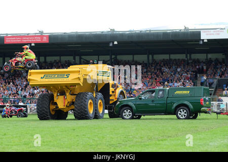 Royal Welsh Show - Montag, 24. Juli 2017 - das Känguru-Kind Motorrad Stuntman niedrig ist wie er versucht, einen grünen Pickup-Truck und einem großen gelben Muldenkipper vor den Zuschauern auf der Royal Welsh Show springen. Seine Quad-Bike trifft jenseits des gelben Kipper LKW wirft ihn zu Boden. Der Stuntman war von Krankenwagen Zustand unbekannt mitgenommen. Heute ist Tag der Eröffnung der größten viertägige Landwirtschaftsausstellung in Großbritannien. Foto-Steven Mai / Alamy Live News Stockfoto