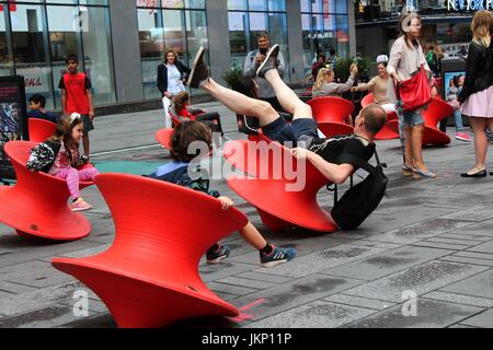New York, uns. 24. Juli 2017. New York, NY, USA. –-24. Juli 2017 jung und jung gebliebene Besucher zum Times Square hielt einen Augenblick inne, mittags Spaß mit Magis gesponnen Stuhl. Die aufrechte gesponnen Stühle ist ein faszinierender Stuhl, der sieht eher aus wie ein skulpturales Gefäß als ein Sitz. Aber wenn es auf seiner Seite lehnt, bildet es einen komfortable Stuhl, mit dem Sie die rock seitliche oder drehen. Bildnachweis: G. Ronald Lopez /DigiPixsAgain.us/Alamy Live-Nachrichten Stockfoto