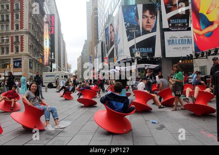 New York, uns. 24. Juli 2017. New York, NY, USA. –-24. Juli 2017 jung und jung gebliebene Besucher zum Times Square hielt einen Augenblick inne, mittags Spaß mit Magis gesponnen Stuhl. Die aufrechte gesponnen Stühle ist ein faszinierender Stuhl, der sieht eher aus wie ein skulpturales Gefäß als ein Sitz. Aber wenn es auf seiner Seite lehnt, bildet es einen komfortable Stuhl, mit dem Sie die rock seitliche oder drehen. Bildnachweis: G. Ronald Lopez /DigiPixsAgain.us/Alamy Live-Nachrichten Stockfoto