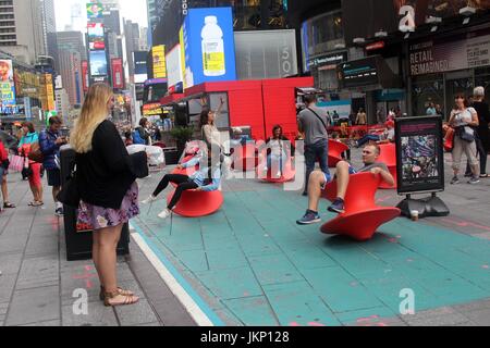 New York, uns. 24. Juli 2017. New York, NY, USA. –-24. Juli 2017 jung und jung gebliebene Besucher zum Times Square hielt einen Augenblick inne, mittags Spaß mit Magis gesponnen Stuhl. Die aufrechte gesponnen Stühle ist ein faszinierender Stuhl, der sieht eher aus wie ein skulpturales Gefäß als ein Sitz. Aber wenn es auf seiner Seite lehnt, bildet es einen komfortable Stuhl, mit dem Sie die rock seitliche oder drehen. Bildnachweis: G. Ronald Lopez /DigiPixsAgain.us/Alamy Live-Nachrichten Stockfoto