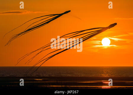 Southport, Merseyside, 24. Juli 2017. Großbritannien Wetter.   Ein schöner sonniger Tag geht zu Ende als zwei Tintenfische schweben in den Himmel fliegen, wie die Sonne über dem Horizont in Southport in Merseyside.  Bildnachweis: Cernan Elias/Alamy Live-Nachrichten Stockfoto