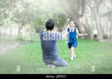 Kinder Schüler in gleichmäßiger Lauf in des Vaters Hände um sie nach hinten in die Schule zu umarmen. Liebe-Konzept Stockfoto