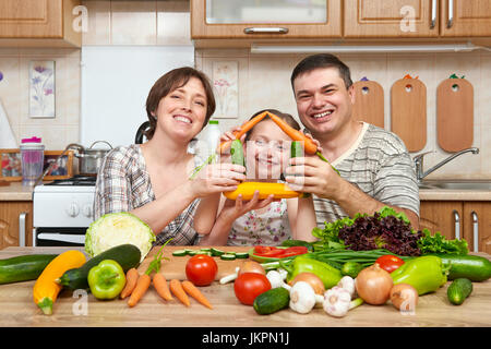 Hausmannskost in Küche Interieur zu Hause, frisches Obst und Gemüse. Gesunde Ernährung-Konzept. Frau, Mann und Kinder. Haus Form von vegeta Stockfoto