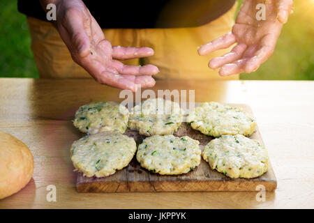 Mann mit schmutzigen Händen nach der Zubereitung von Fleisch und Zucchini-Burger, Bbq-Sommer-Garten Food-Konzept Stockfoto