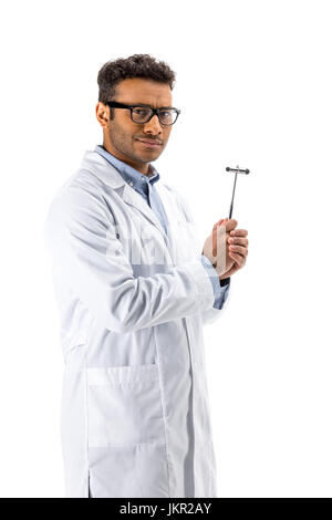 Junge professionelle Arzt in Brillen halten Reflexhammer isoliert auf weiss Stockfoto