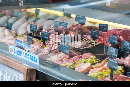 Blick durch ein Metzger-Schaufenster mit verschiedenen Arten von Fleisch für den Verkauf in Deutschland. Stockfoto