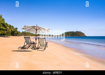 Tropischen unberührten Strand mit Liegestühlen und Sonnenschirm in Nosy Be, Madagaskar Stockfoto