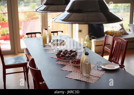 Erhöhte Ansicht von Pendelleuchten über Speisen am Esstisch zu Hause hängen Stockfoto