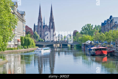 STRAßBURG DAS VIERTEL PETITE FRANCE UND FLUSS L ' ILL BLICK AUF DIE KATHEDRALE TÜRME UND EIN TOURISTENBOOT Stockfoto