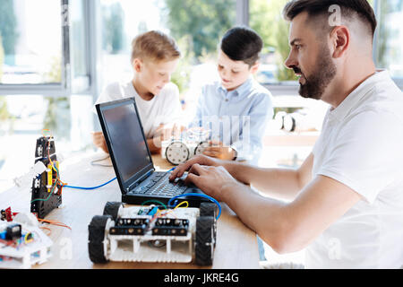 Junge Robotik Lehrer arbeiten auf dem laptop Stockfoto