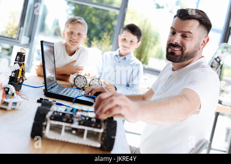 Mann, die Anpassung des Drahtes in einem Roboter-Auto Stockfoto