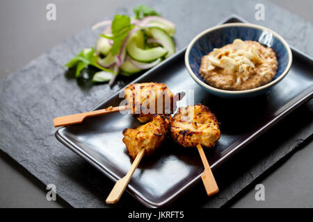 Chicken Satay, Zwiebel und Gurke Salat Stockfoto