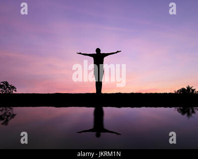 Silhouette-Mann mit offenen Armen allein stehend Stockfoto