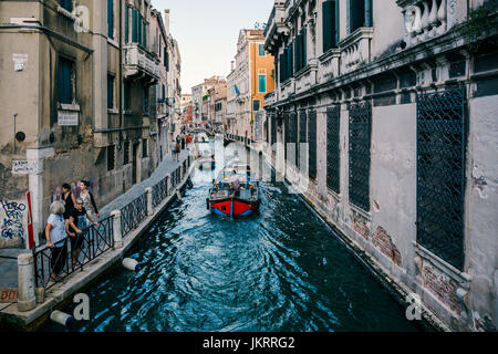 Venezianischen Straße Kanal mit verschiedenen Booten drauf, laufen die Touristen an. Venedig ist ein beliebtes Reiseziel für seine Einzigartigkeit und gefeierten ar Stockfoto