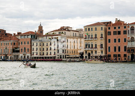 Gondel auf dem Canal Grande in Venedig gegen die bunten Häusern. Boote sind die wichtigsten Transportmittel in der Stadt. Stockfoto