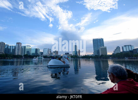 Swan geformte Paddelboote am Lake Eola Park mit der Downtown Orlando Skyline im Hintergrund Am 4. Juli. Stockfoto