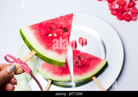 Weiblich, hält ein Stück Wassermelone Obst auf Eis-stick Stockfoto