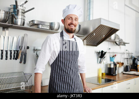 Erfolgreiche Chef lehnt sich am Arbeitsplatz in der Küche Stockfoto