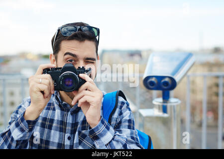 Porträt von gut aussehenden jungen Mann Aufnahme mit Vintage Foto-Kamera Stockfoto