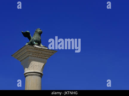 Saint Mark Lion antike Bronzestatue an der Spitze der mittelalterlichen Spalte, errichtet im Jahre 1172. Symbol der alten Republik Venedig (mit blauem Himmel und Kopie Stockfoto