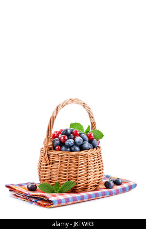 Korb mit Heidelbeeren und roten Johannisbeeren, die isoliert auf weißem Hintergrund. Stockfoto