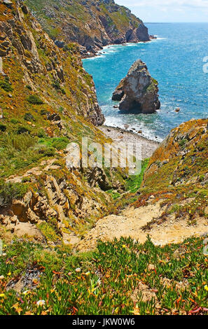 Die schmale Hiddenpath zwischen den Felsen führt zum Lourical Strand, bekannt für malerische Felsbrocken am Ufer, Cabo da Roca, Sintra, Portugal. Stockfoto