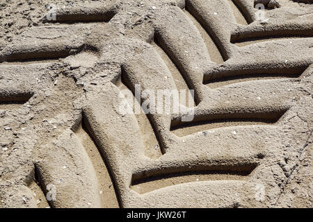 Tire tread Fußspuren eines Traktors auf dem Sand. Stockfoto