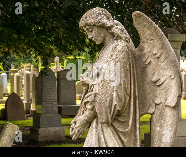 Alte Stein geschnitzte Engel mit gesenktem Kopf, und traurig schwermütige Ausdruck, die St Mary's Stiftskirche Friedhof, Haddington, East Lothian, Schottland, Großbritannien Stockfoto