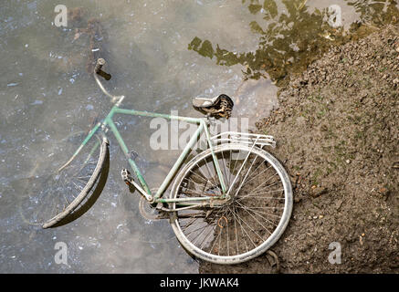 Ein altes Fahrrad in einen Kanal geworfen Stockfoto
