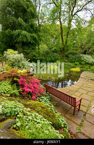 Spektakuläre Gemeinschafts-Garten mit Wasserspiel, Pflasterarbeiten, Picknick-Tisch und Bäume spiegeln sich im Wasser des ruhigen Pool - in Schottland Stockfoto