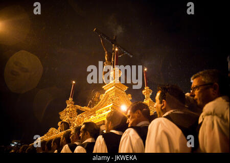 Mitglieder aus der Mena-Bruderschaft führen den Thron des Christus des guten Todes unter dem Regen während der Prozession des Gründonnerstags in Malaga, Spanien. Datum: 21.04.2011. Fotograf: Xabier Mikel Laburu Van Woudenberg.---Miembros De La Cofradía de Mena Transportan el Trono del Santísimo Cristo De La Buena Muerte, Bajo la Lluvia, Durante la Procesión del Jueves Santo de Málaga, España. Fecha:21/04/2011. FOTÓGRAFO: Xabier Mikel Laburu Van Woudenberg. Stockfoto