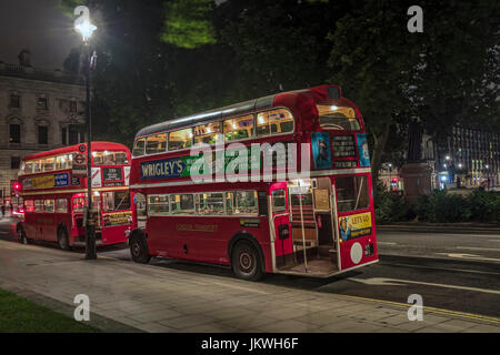 Zwei rote Oldtimer Busse in Parliament Square bei Nacht Stockfoto