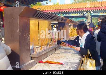 HONG KONG, CHINA - 22. Januar 2017: Nicht identifizierten Personen brennen Räucherstäbchen innerhalb der Wong Tai Sin buddhistischen Tempel in Hong Kong, China zu beten. Stockfoto