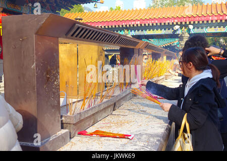 HONG KONG, CHINA - 22. Januar 2017: Nicht identifizierten Personen brennen Räucherstäbchen innerhalb der Wong Tai Sin buddhistischen Tempel in Hong Kong, China zu beten. Stockfoto