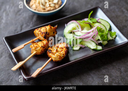 Chicken Satay, Zwiebel und Gurke Salat Stockfoto