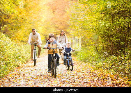 Junge Familie in warme Kleidung, Radfahren im Herbst park Stockfoto