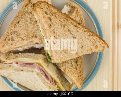 Teller mit verschiedene Sandwiches in Schwarzbrot gegen eine leichte Kiefer-Holz-Hintergrund Stockfoto