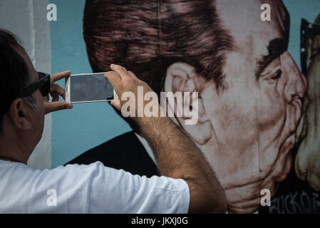 Berlin, Deutschland. 20. Juli 2017. Besucher zu Fuß entlang der East Side Gallery, ein Meile-langes Teilstück der Berliner Mauer noch steht, d. h. in Wandmalereien und Graffiti, am 20. Juli 2017, in Berlin, Deutschland abgedeckt. Die Arbeit von 118 Künstlern aus 21 Ländern ist auf dem Display, Sehenswürdigkeiten aus dem kalten Krieg, als die Stadt, zwischen Ost geteilt war und West, sind jetzt große Touristenattraktionen. Bildnachweis: Andrea Ronchini/Pacific Press/Alamy Live-Nachrichten Stockfoto